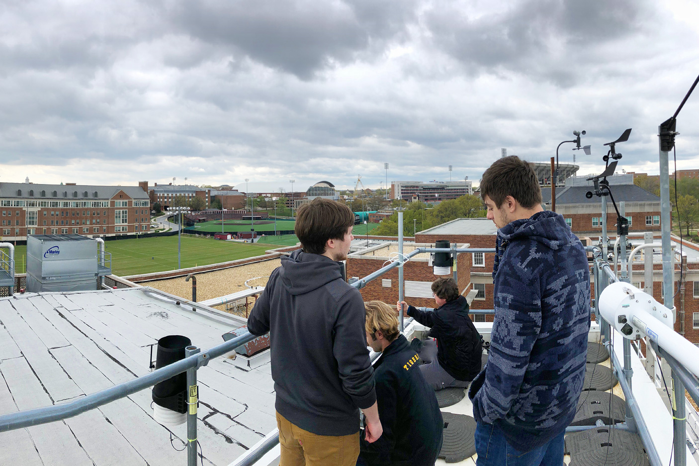 Students conducting weather research on a rooftop on campus.