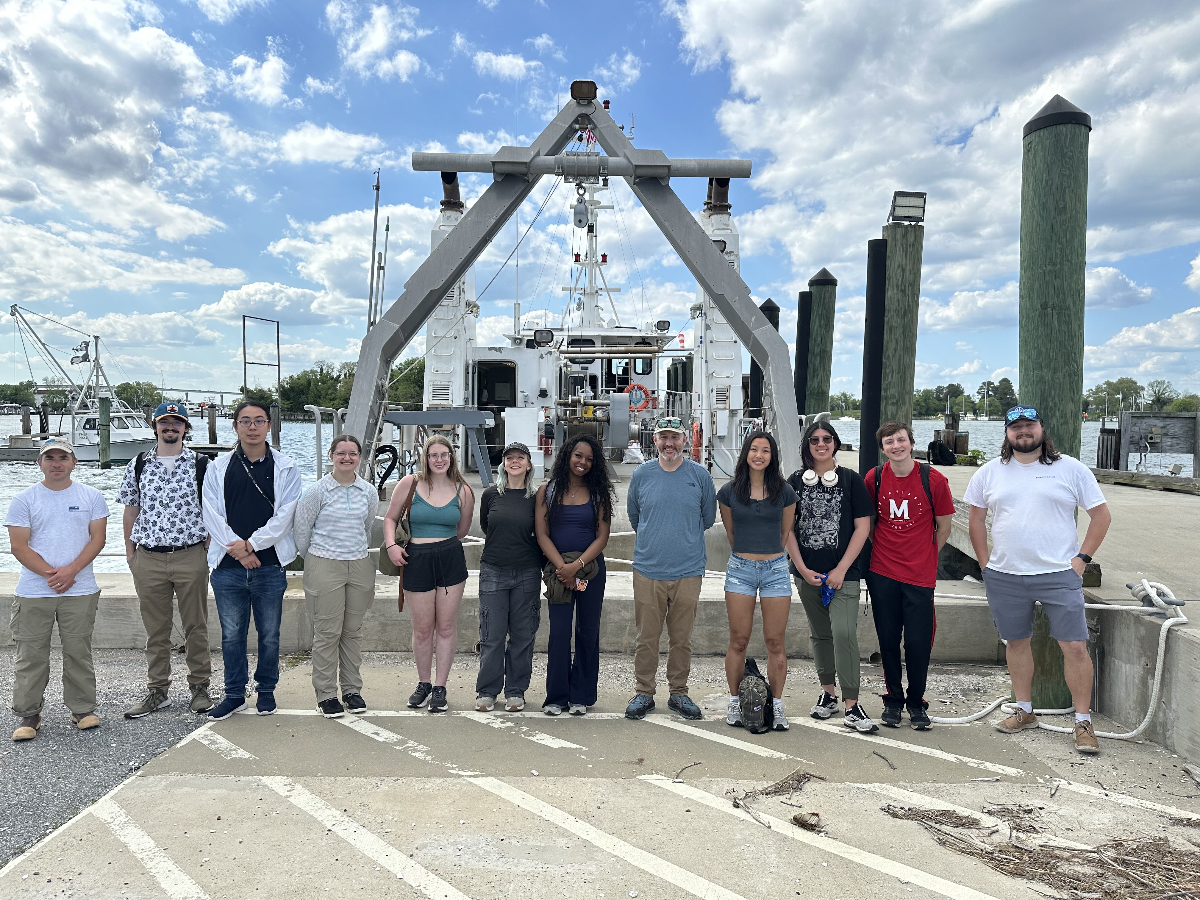 Students lined up posing on the dock in front of the ship