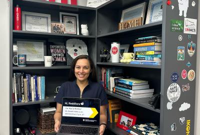 Maria Molina holding an open laptop