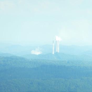 power plant smoke stacks in the hazy distance 