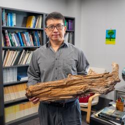 Ning holding a 3,775 year old log
