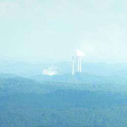 power plant smoke stacks in the hazy distance 